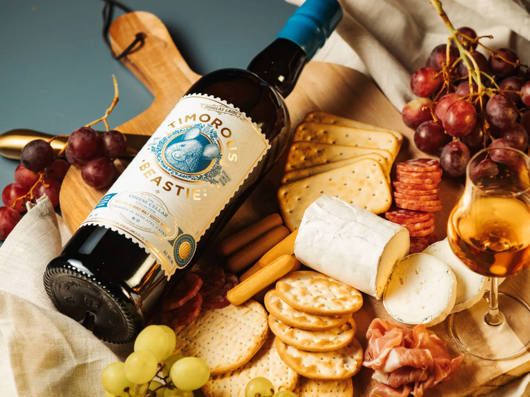 De Douglas Laing Timorous Beastie Scheese Cellar Collection 3 whisky op een plankje met kaas en crackers