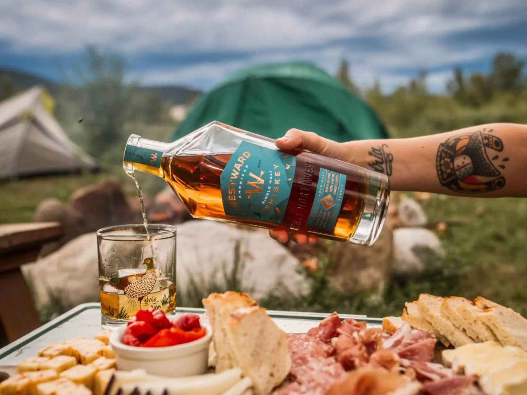 Westward whiskey wordt ingeschonken in de natuur bij een tafel eten.