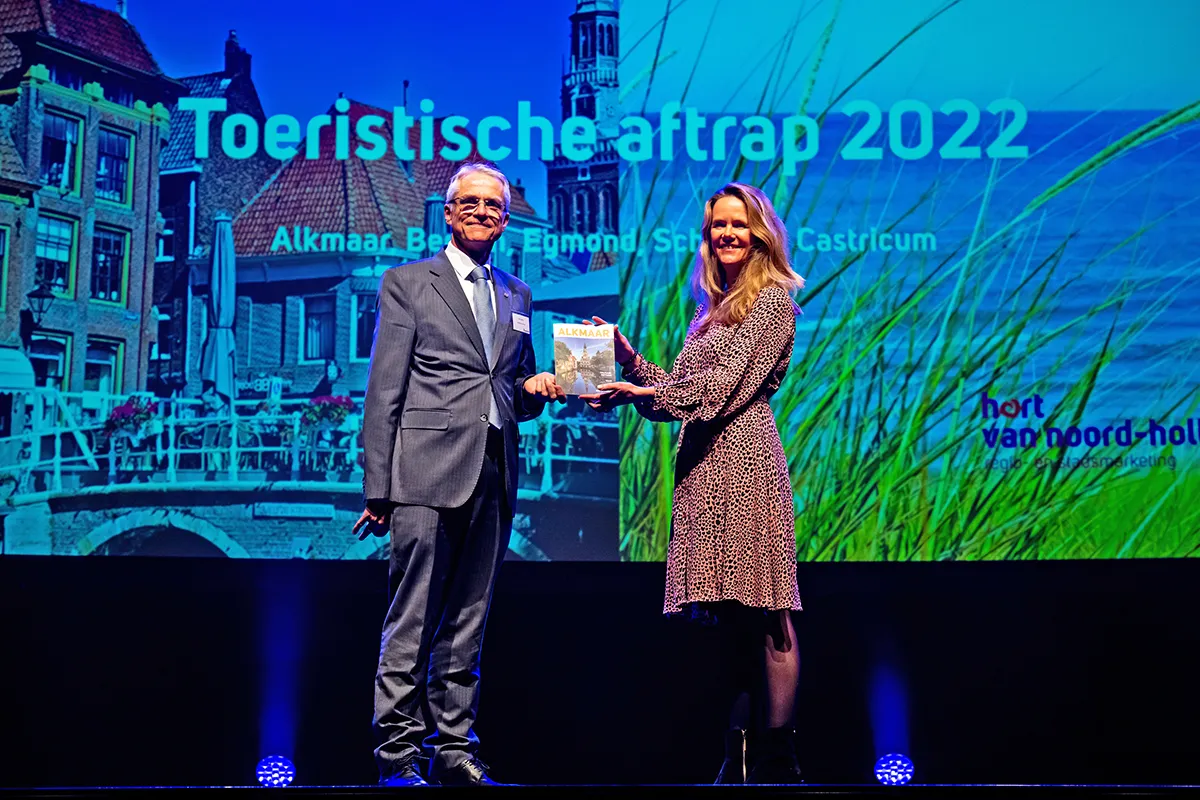 melanie goudsblom marketingmanager alkmaar marketing reikt het eerste exemplaar van het toeristisch magazine uit aan wethouder pieter dijkman