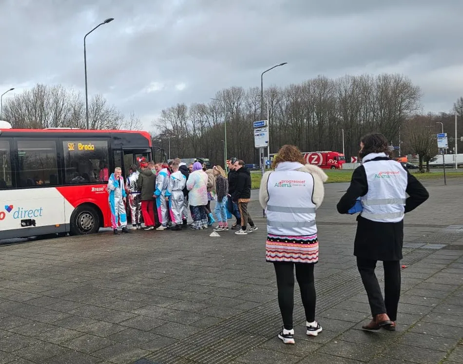 Carnavalsvierders-bij-een-bus-met-daarbij-2-vertegenwoordigers-van-Progressief-Altena