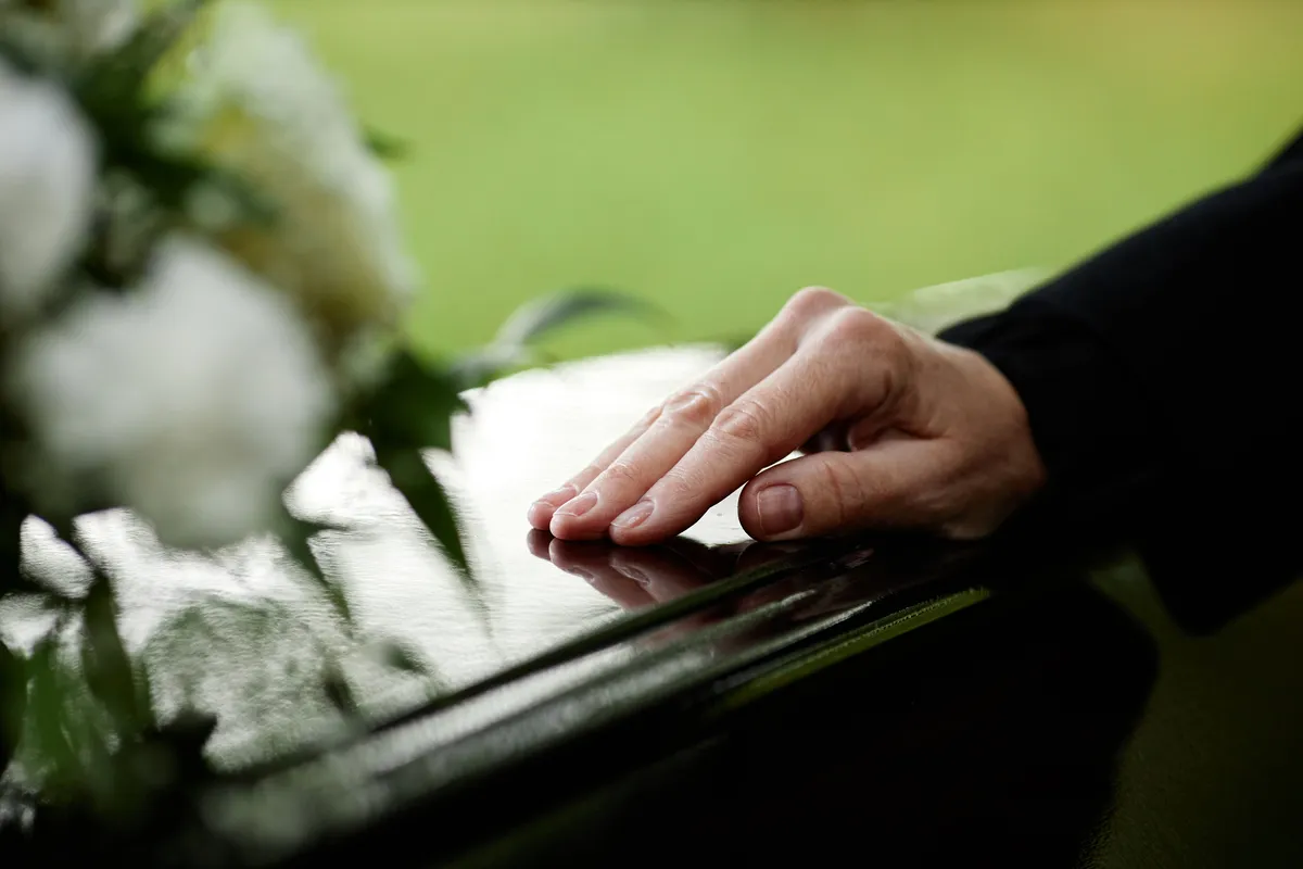 closeup womans hand coffin saying goodbye outdoor funeral ceremony copy space3