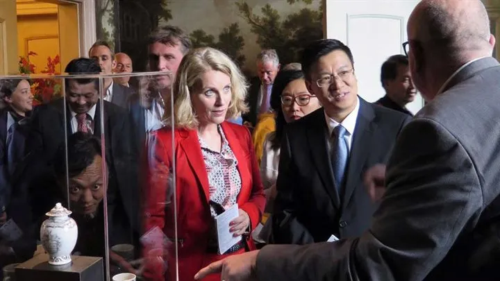 genodigden bij chinese vaas in vitrine