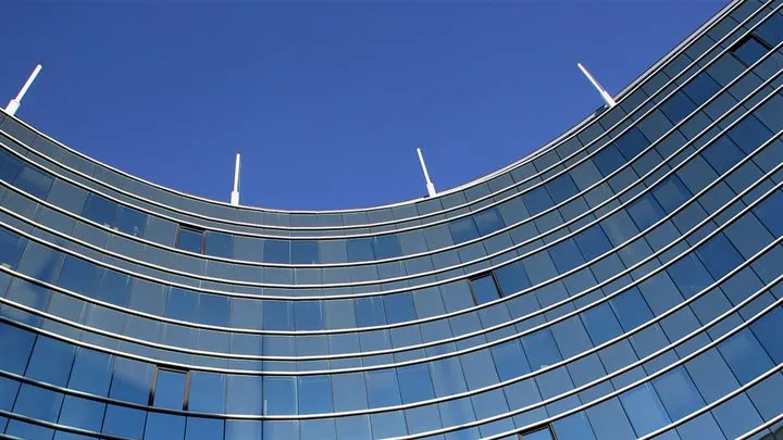 kantoor met spiegelende ruiten met blauwe lucht erboven