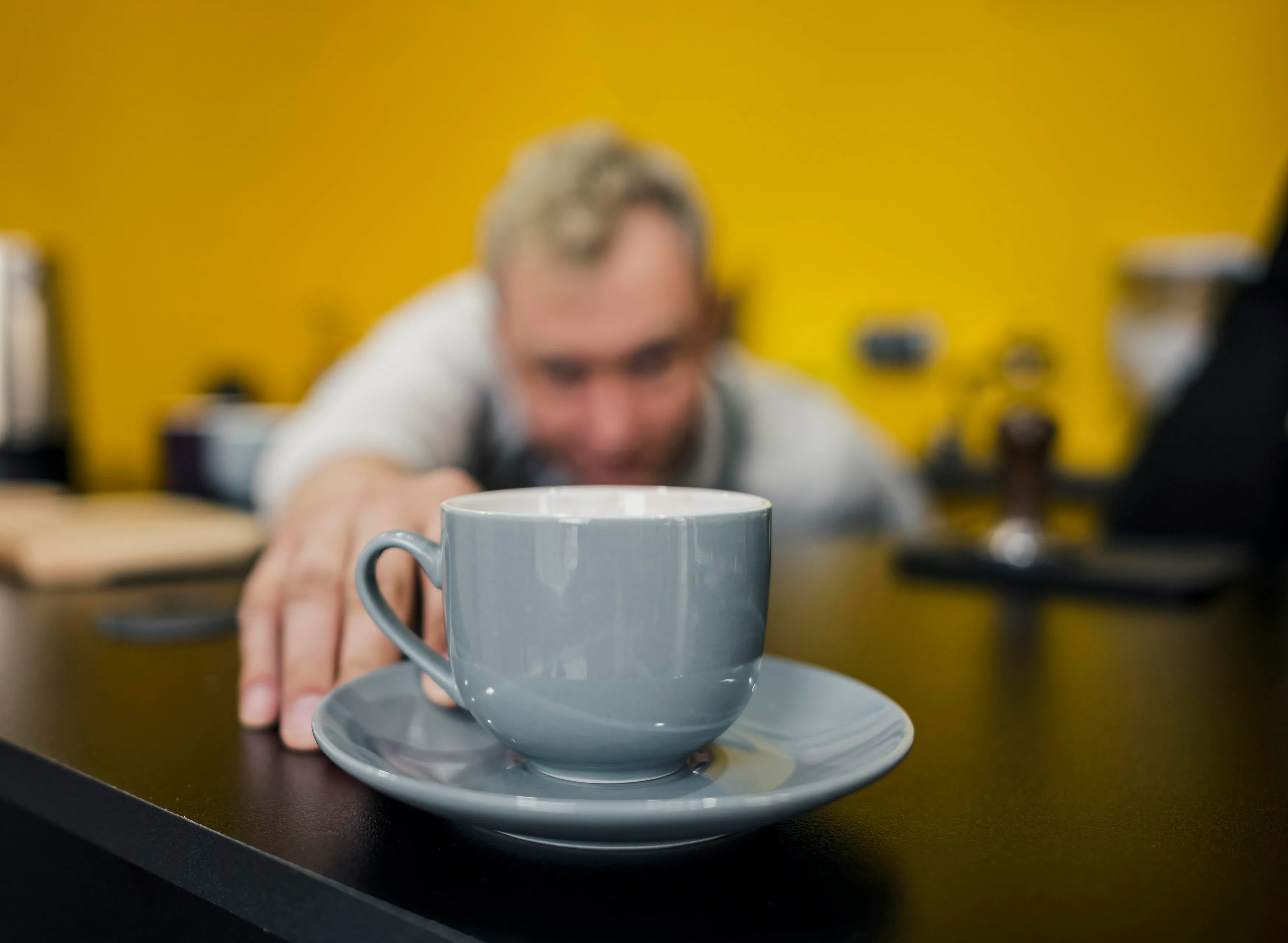 front view defocused barista looking cup coffee