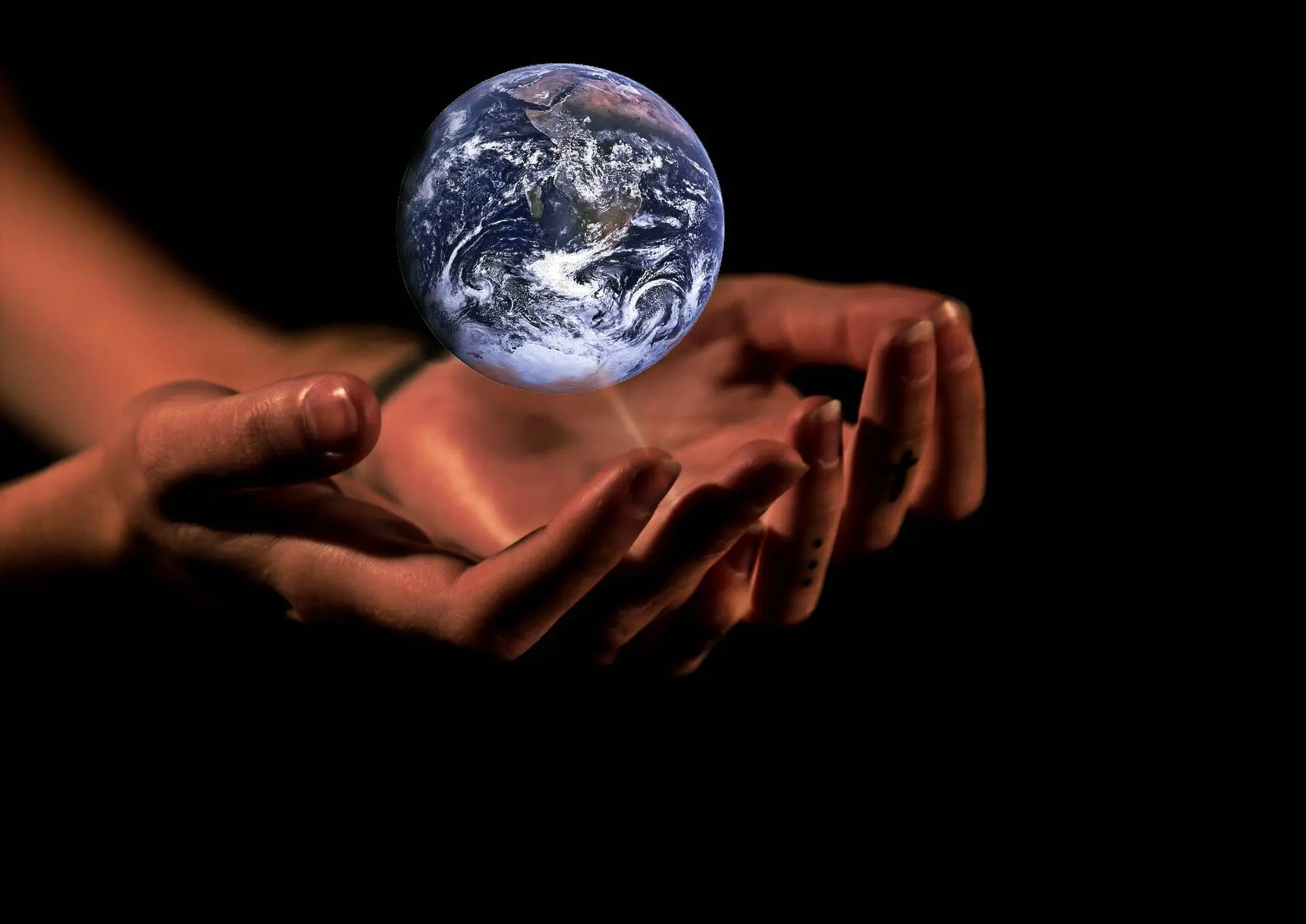 Handen met een afbeelding van de aarde als symbool voor het klimaat