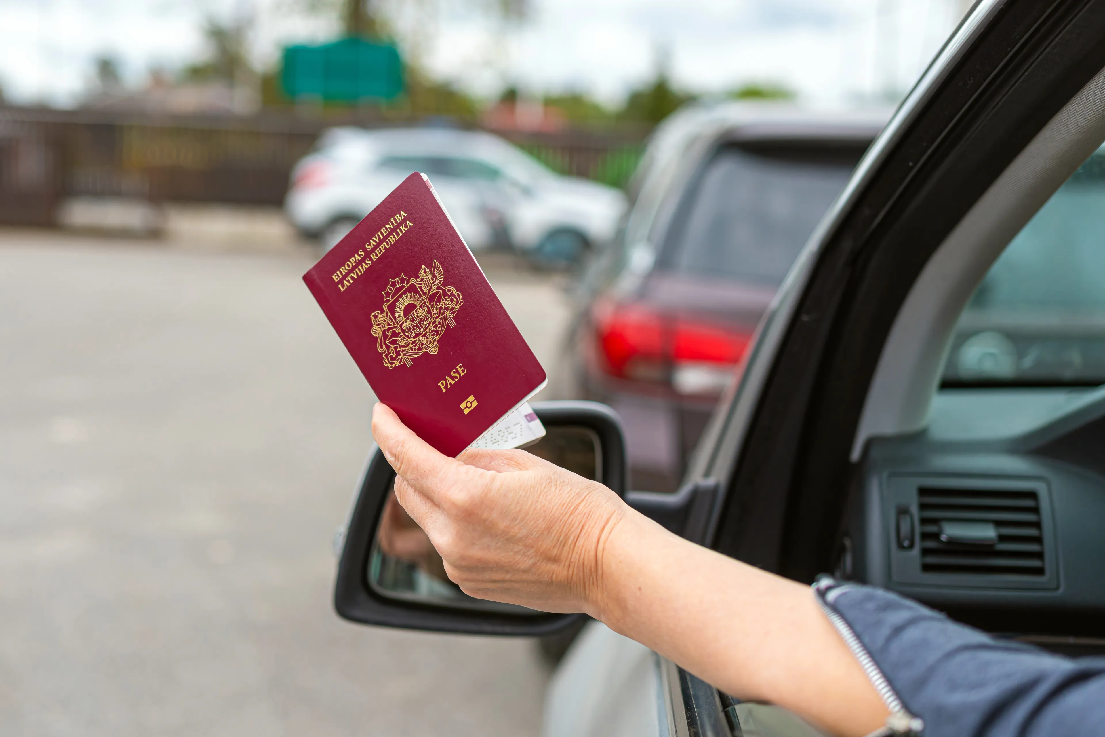 women hand through car window giving passport for 2023 11 27 05 06 36 utc