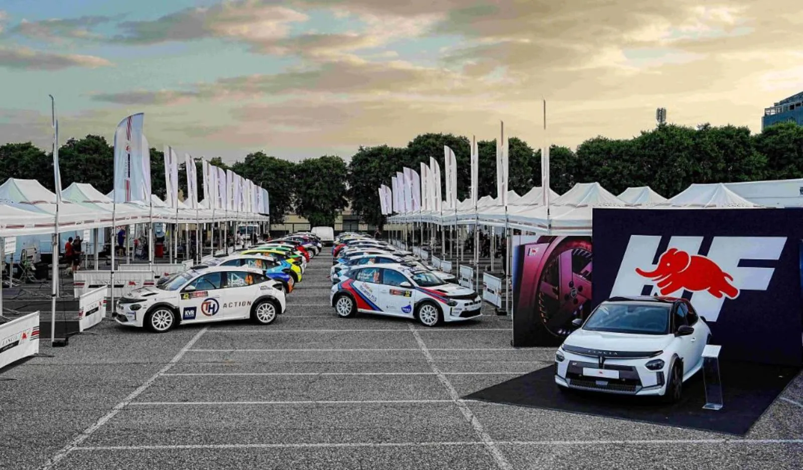 alcune auto rally lancia in allestimento da gara in un parcheggio al tramonto