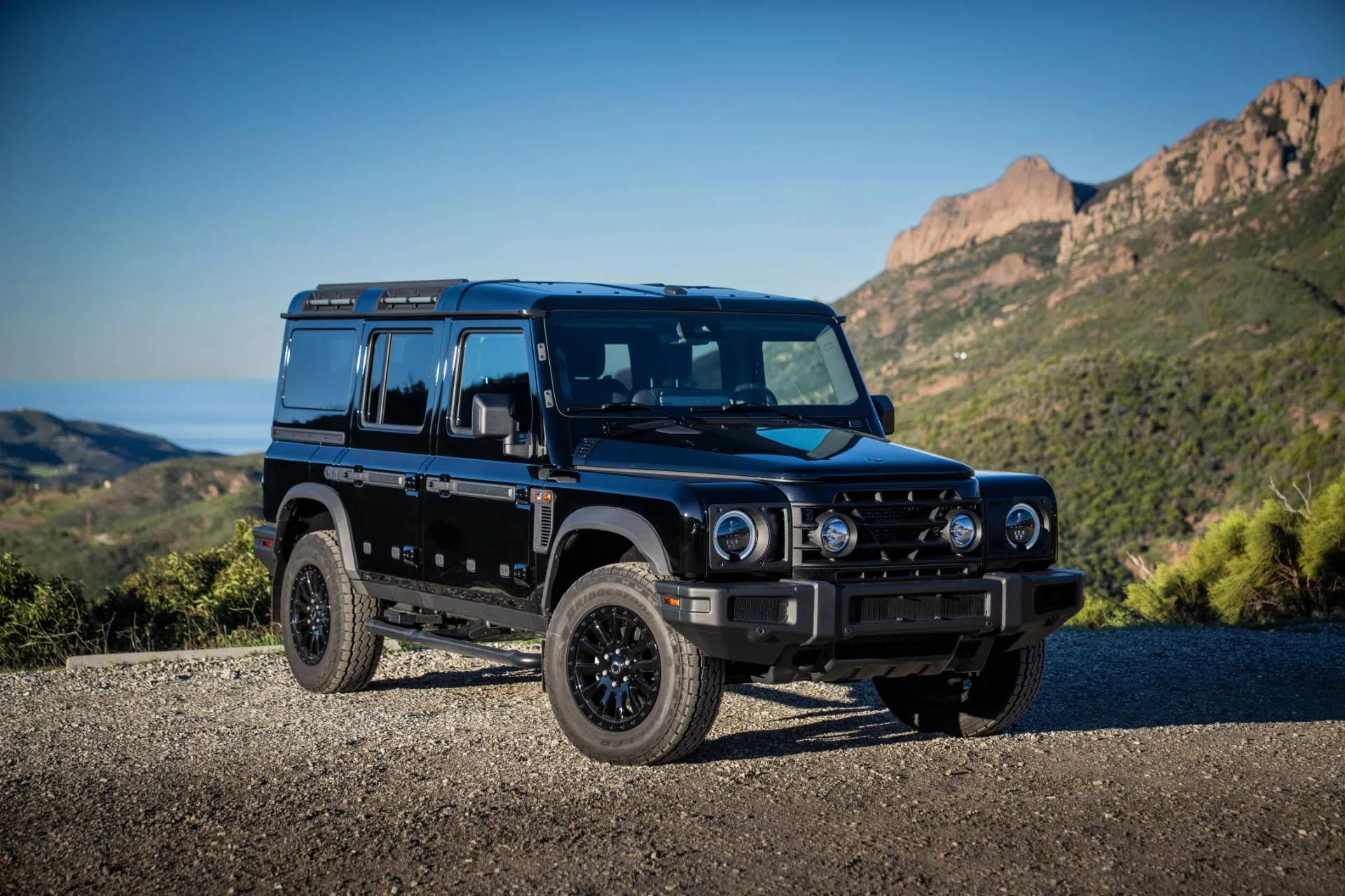 La Ineos Grenadier del 2026 nella versione black edition di colore nero con sfondo delle montagne