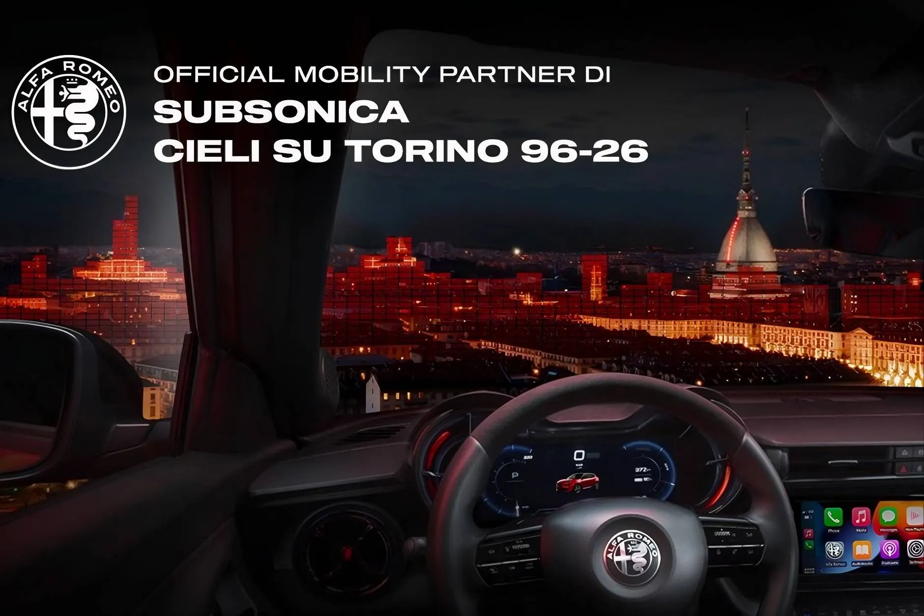 immagine dell'interno di una alfa romeo junior con sfondo di torino di notte mole antonelliana e centro città illuminato. in alto a sinistra la scritta che parla della partneship tra alfa romeo e il gruppo musicale subsonica