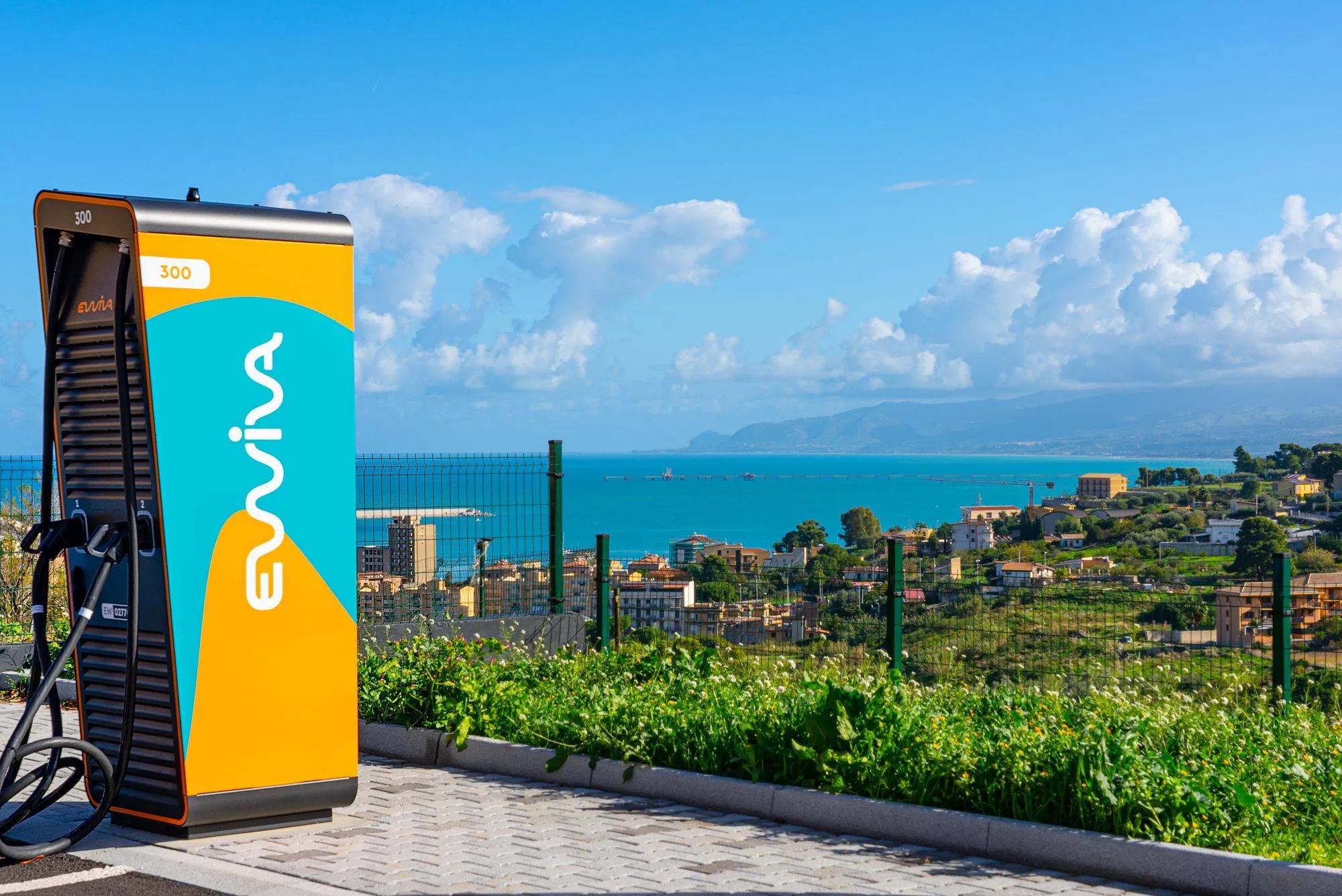 colonnina di ricarica veloce ewiva con sfondo del mare e della liguria