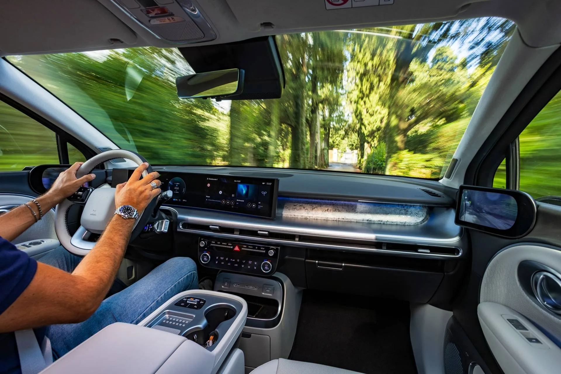 Hyundai IONIQ 9 interni in movimento con mani che guidano il volante