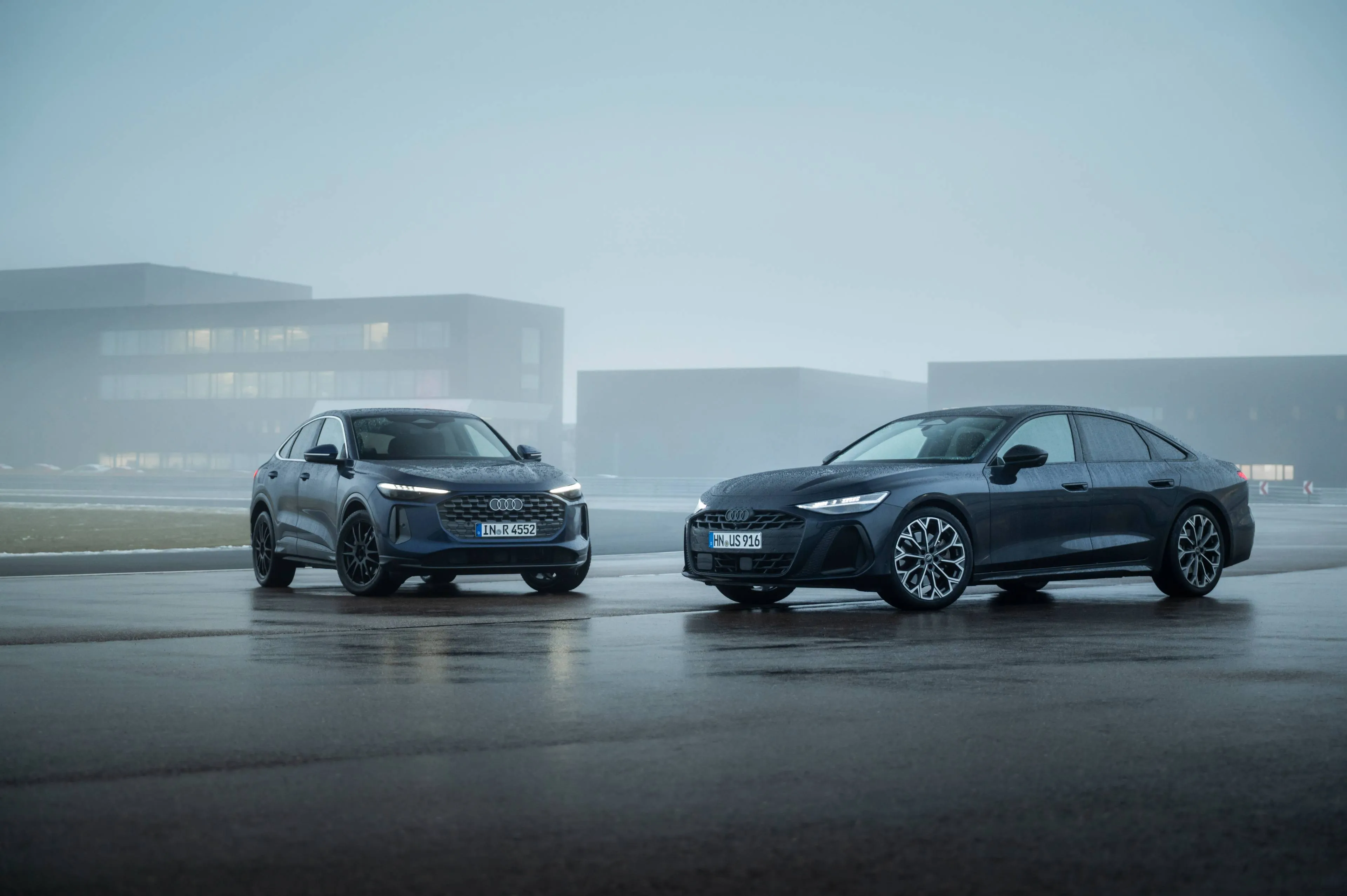 AUDI Q5 sportback e Audi A6 con il V6 posizionate una affianco all'altra con sfondo palazzi e nebbia