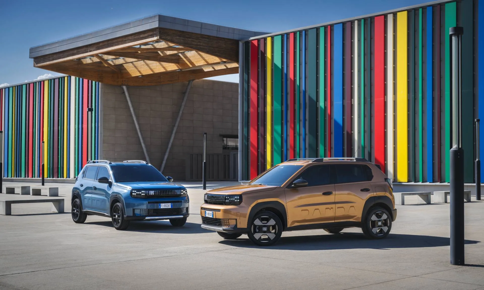 FIAT Grande Panda Hybrid in due colorazioni diverse di fronte alla sede della J arena a torino. Un esemplare in blu l'altro in bronzo sotto al sole