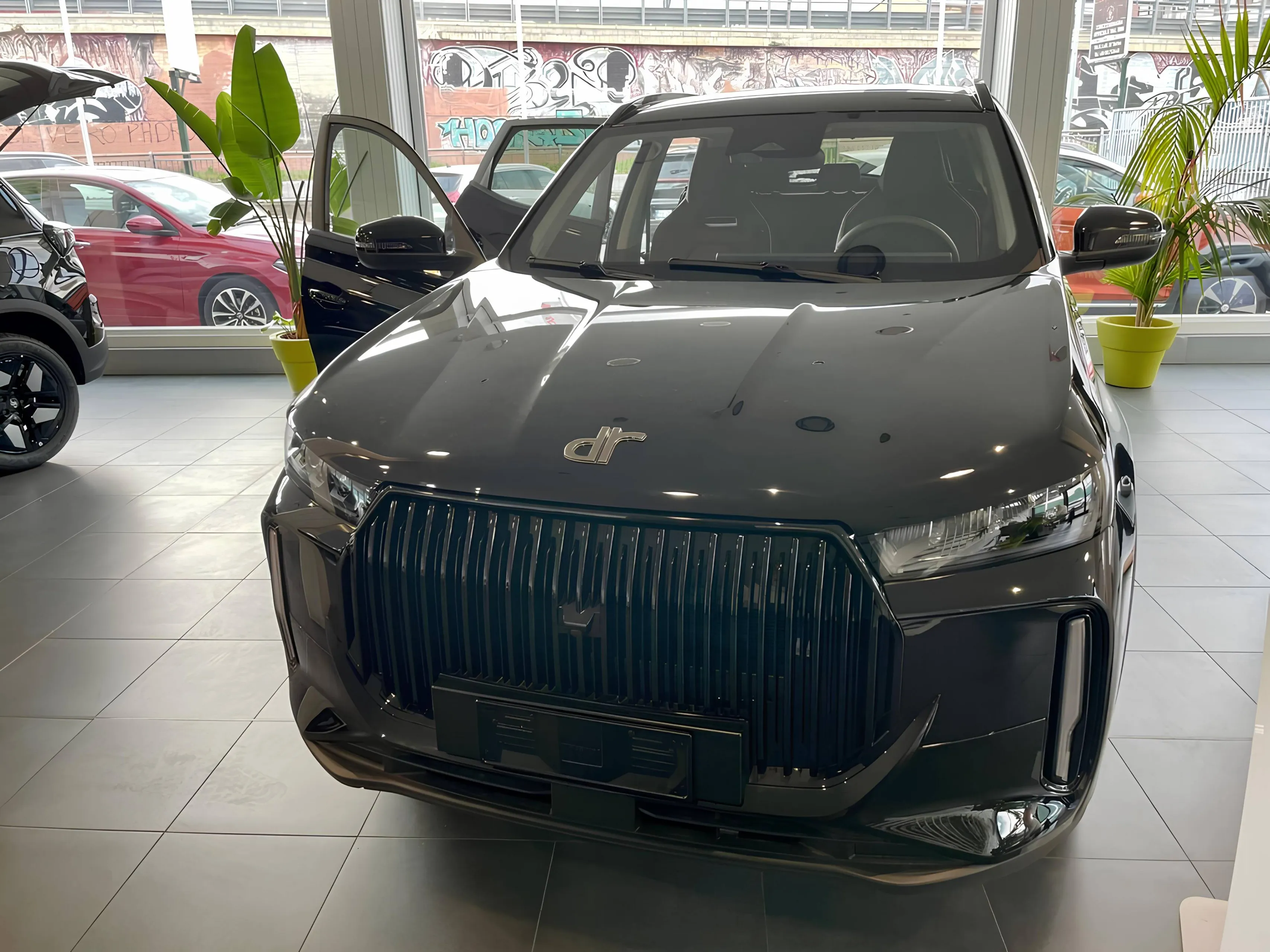 SUV DR 5 CINESE IN SHOWROOM NERA CON SFONDO CHIARO E PIANTE