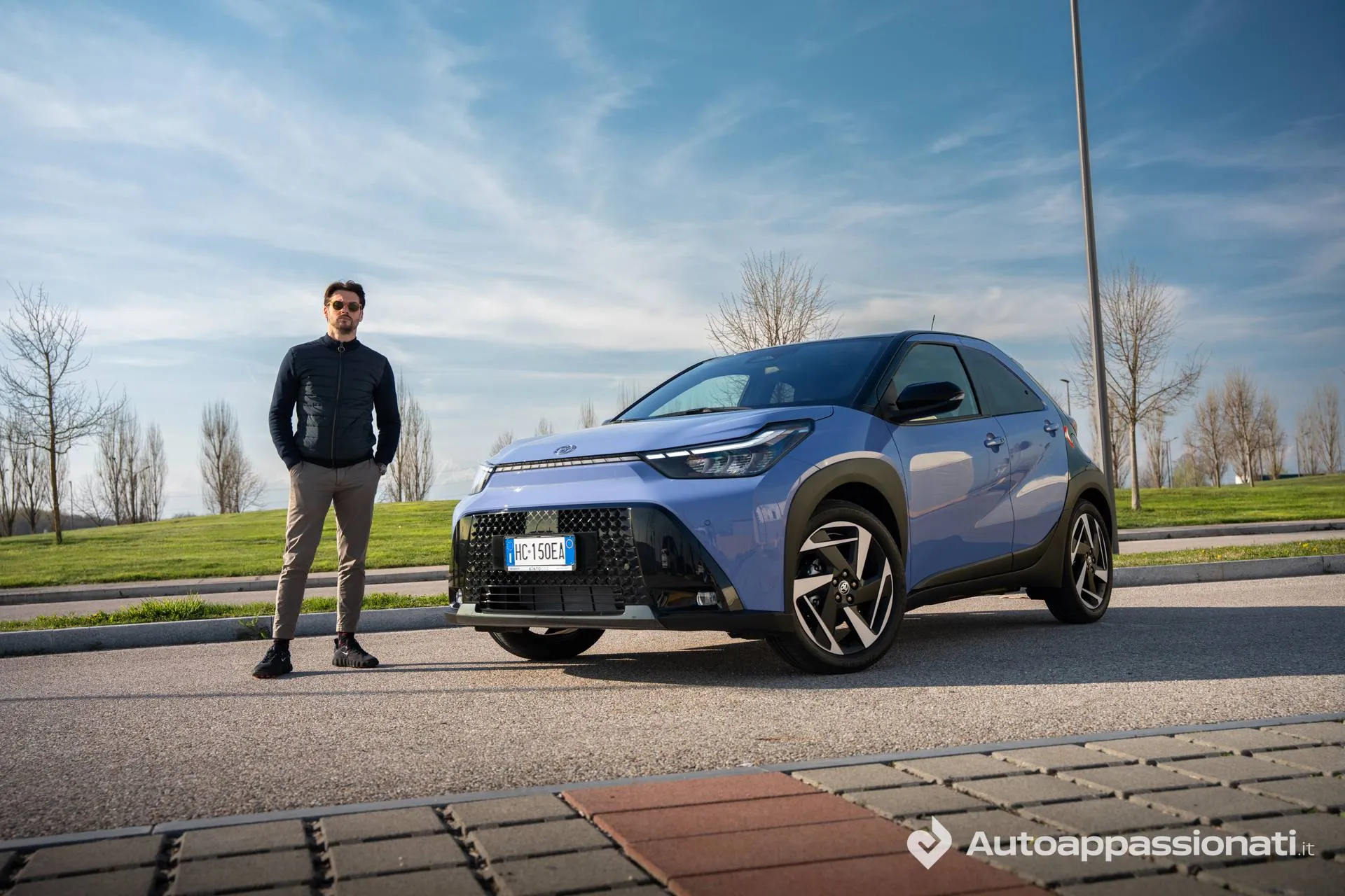 Toyota-Aygo-X-hybrid casetta affianco all'auto viola