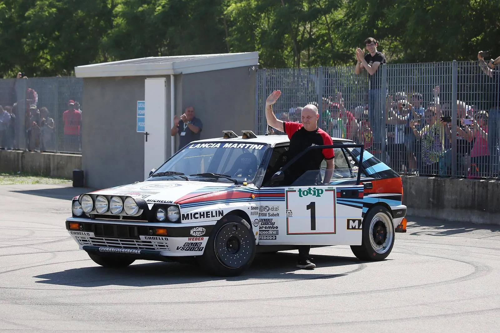 Pilota Miki Biasion con Lancia Delta campione sfondo pubblico rally