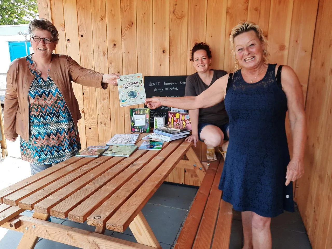 foto overhandiging tuinboeken buurttuin links bibliotheekmedewerker aafke vlaanderen oldenzeel rechts vrijwilliger annette achter tineke hopman