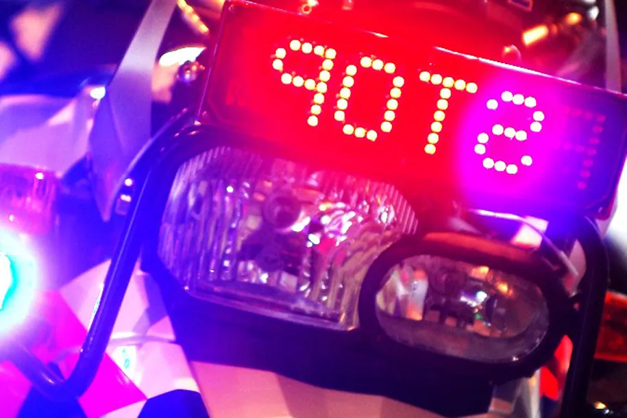 surveillancemotor met zwaailicht en stopbord