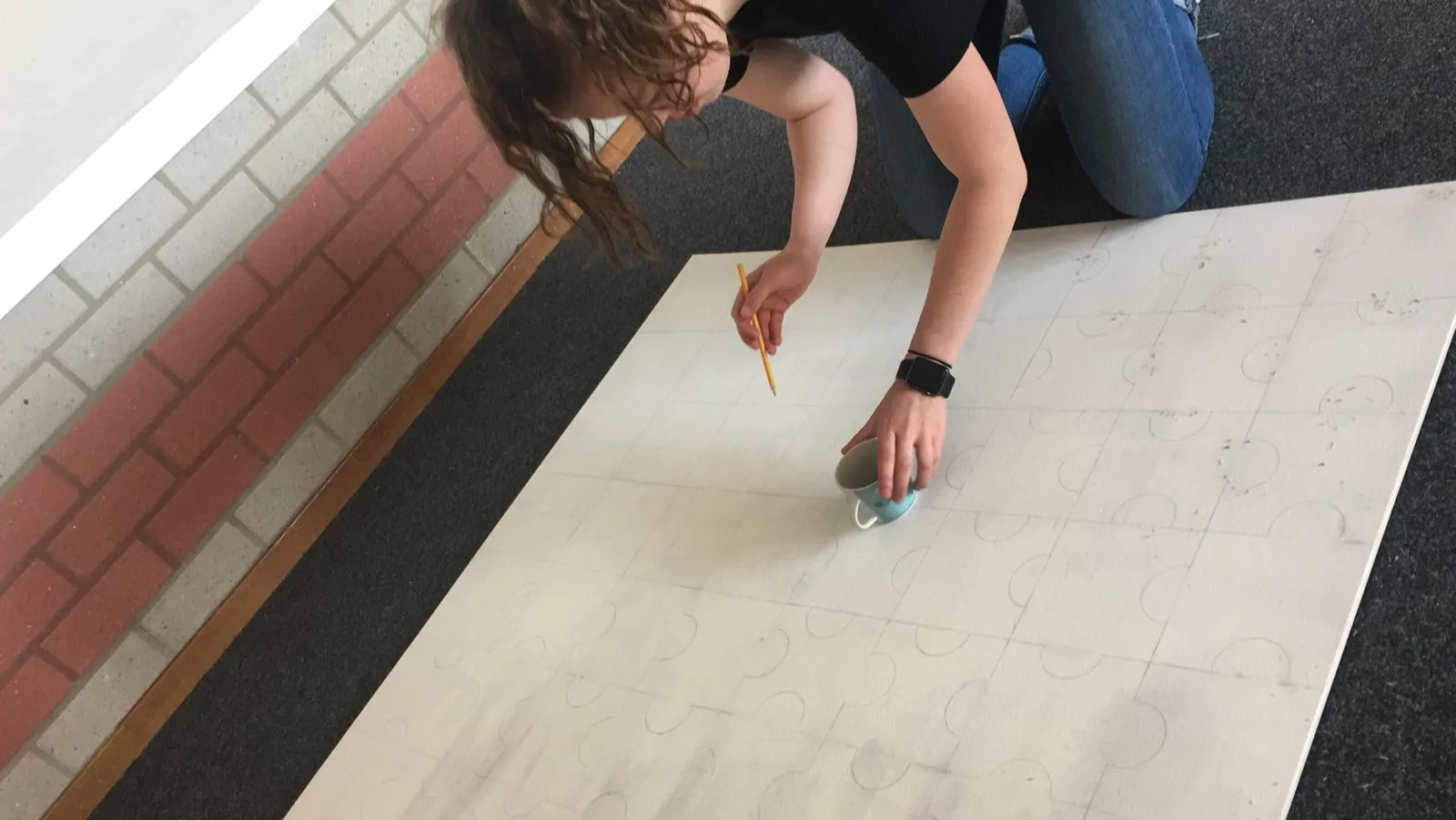 foto lastisha anouschka aan het werk met de puzzelstukken uittekenen