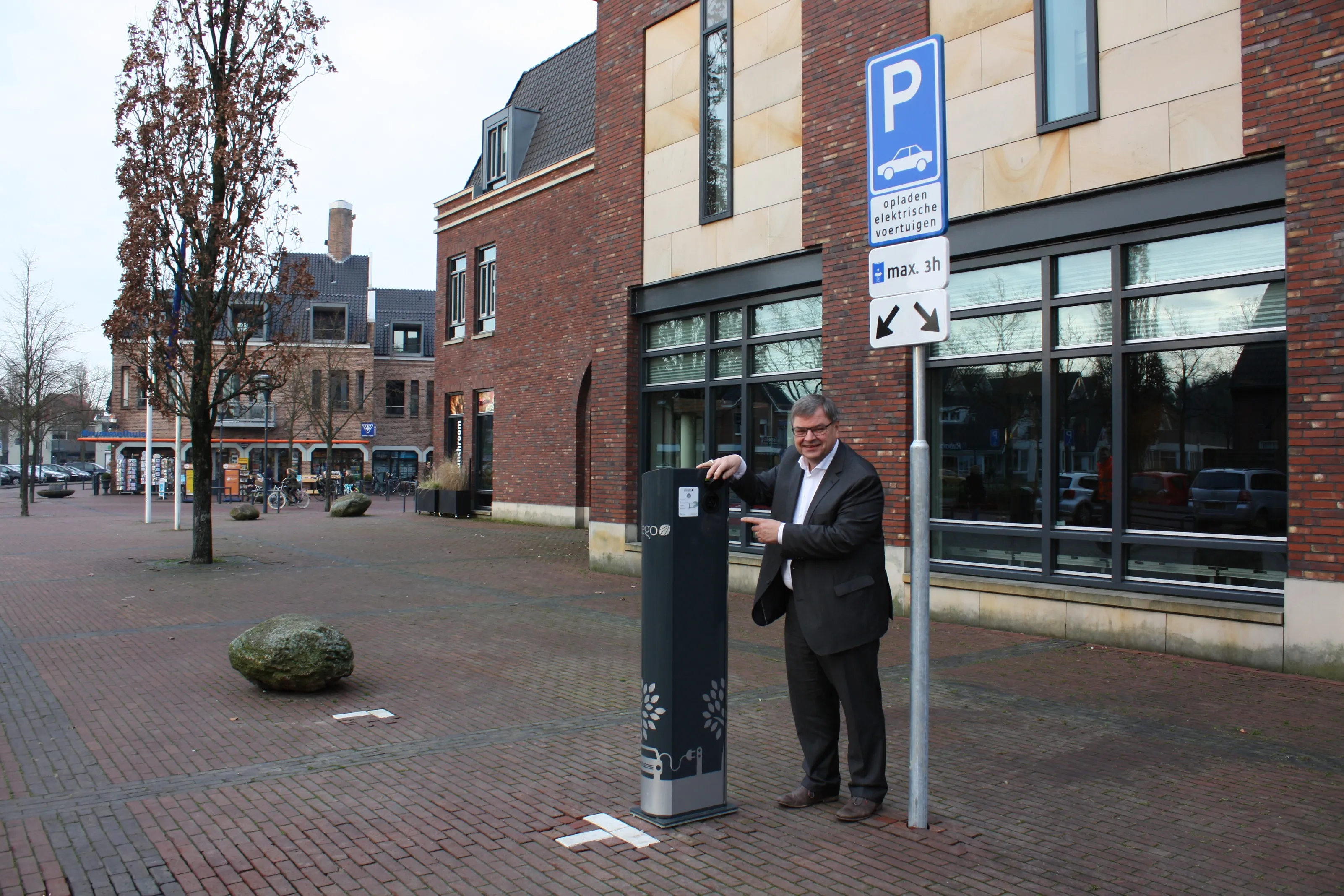 wethouder steggink naast laadpaal bij gemeentehuis
