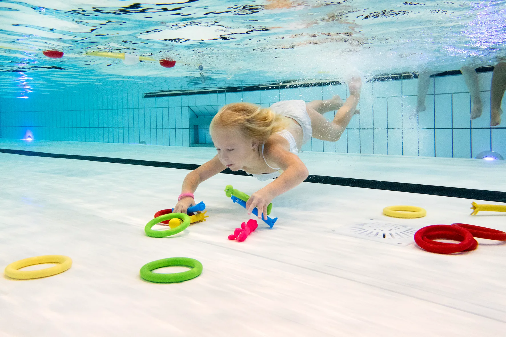 3-meisje-duikt-ringen-op-onder-water