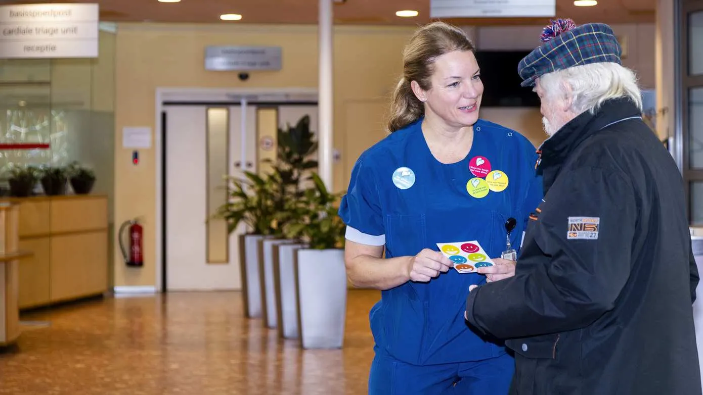 Collega Miranda Savenije deelt buttons uit aan bezoekers en patiënten