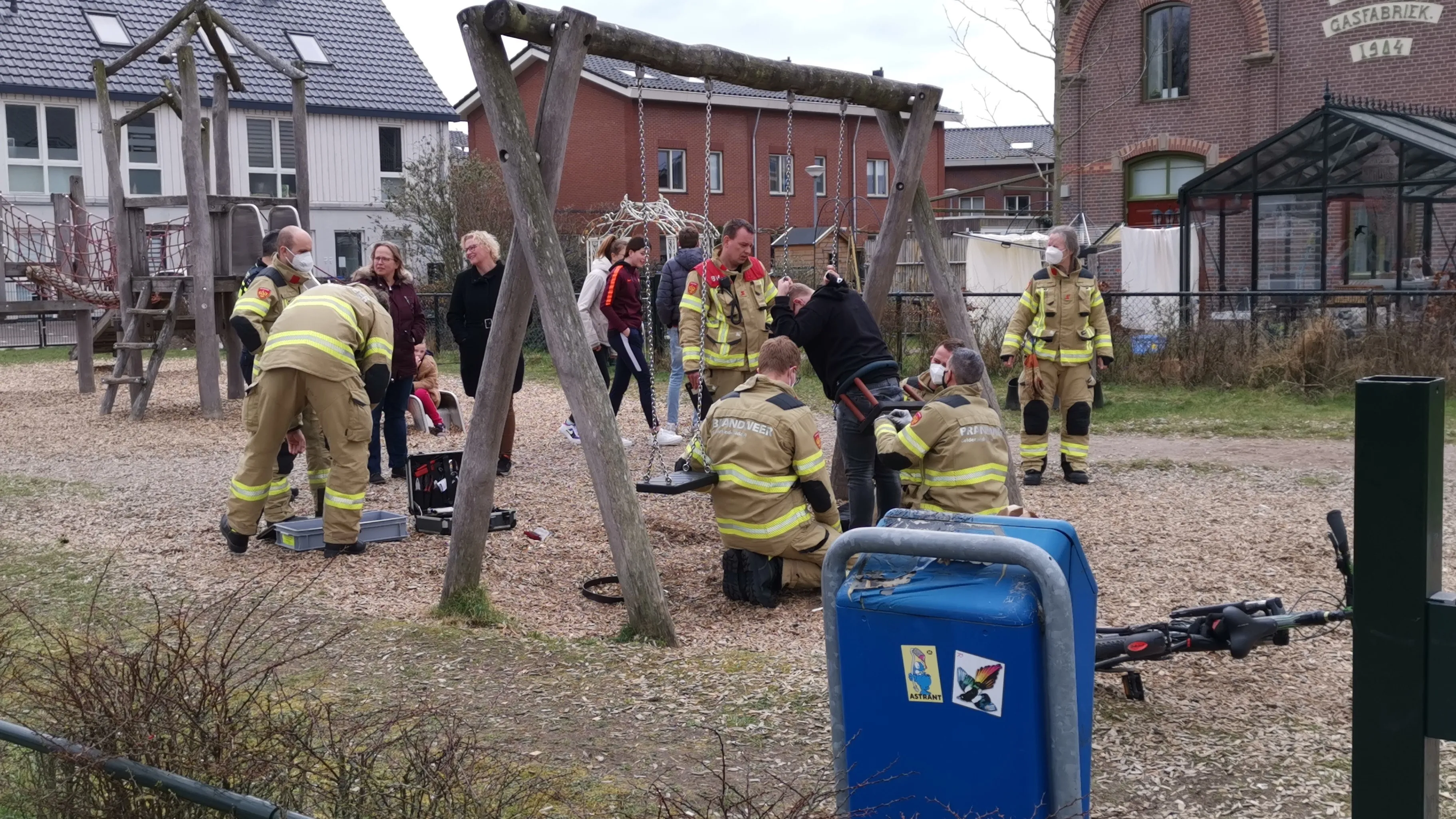 man beknelt op speeltoestel