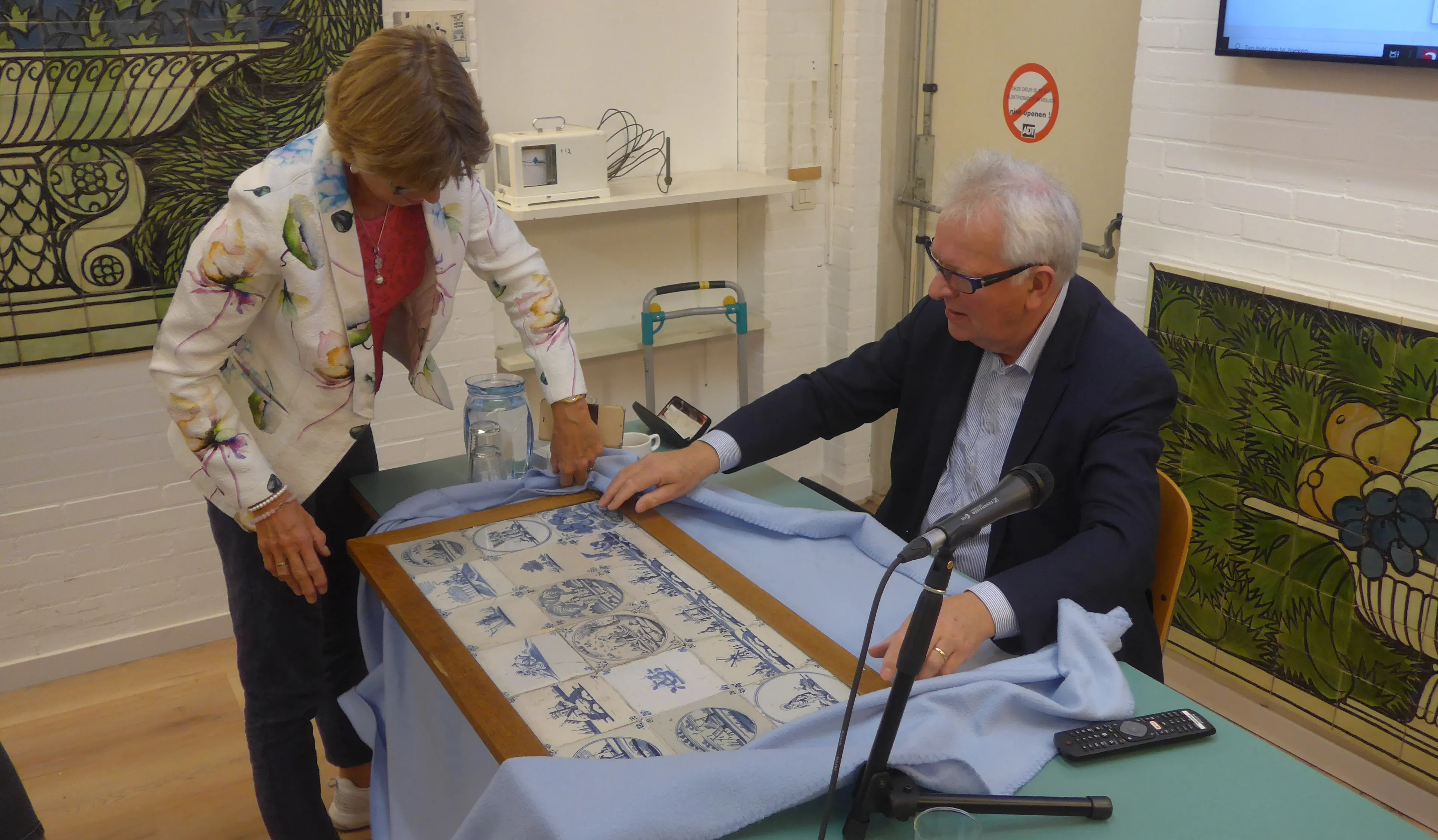 taxateur ger de ree bekijkt een tegeltableau