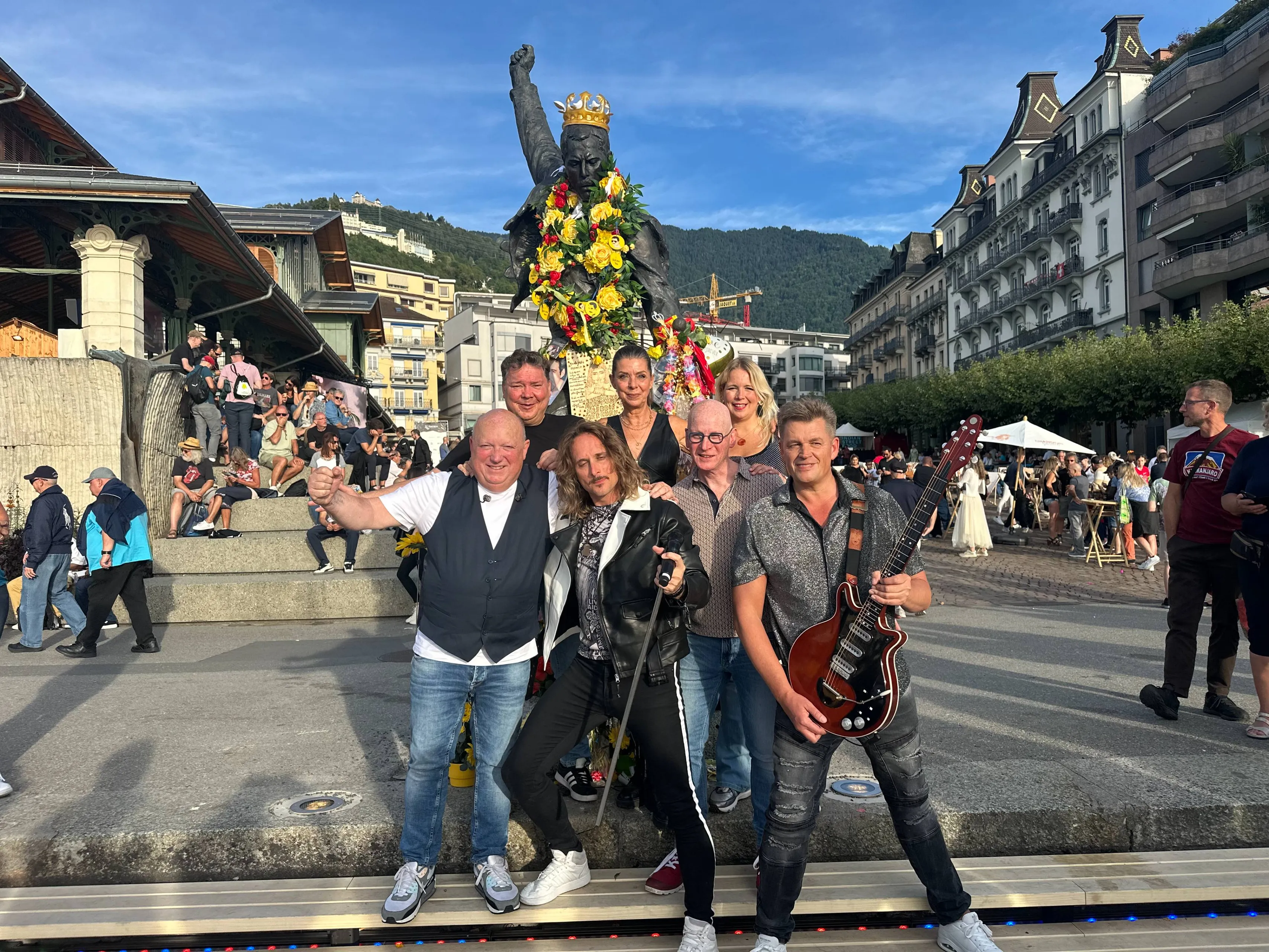 Bandfoto Crazy Little Things bij Freddie Mercury statue