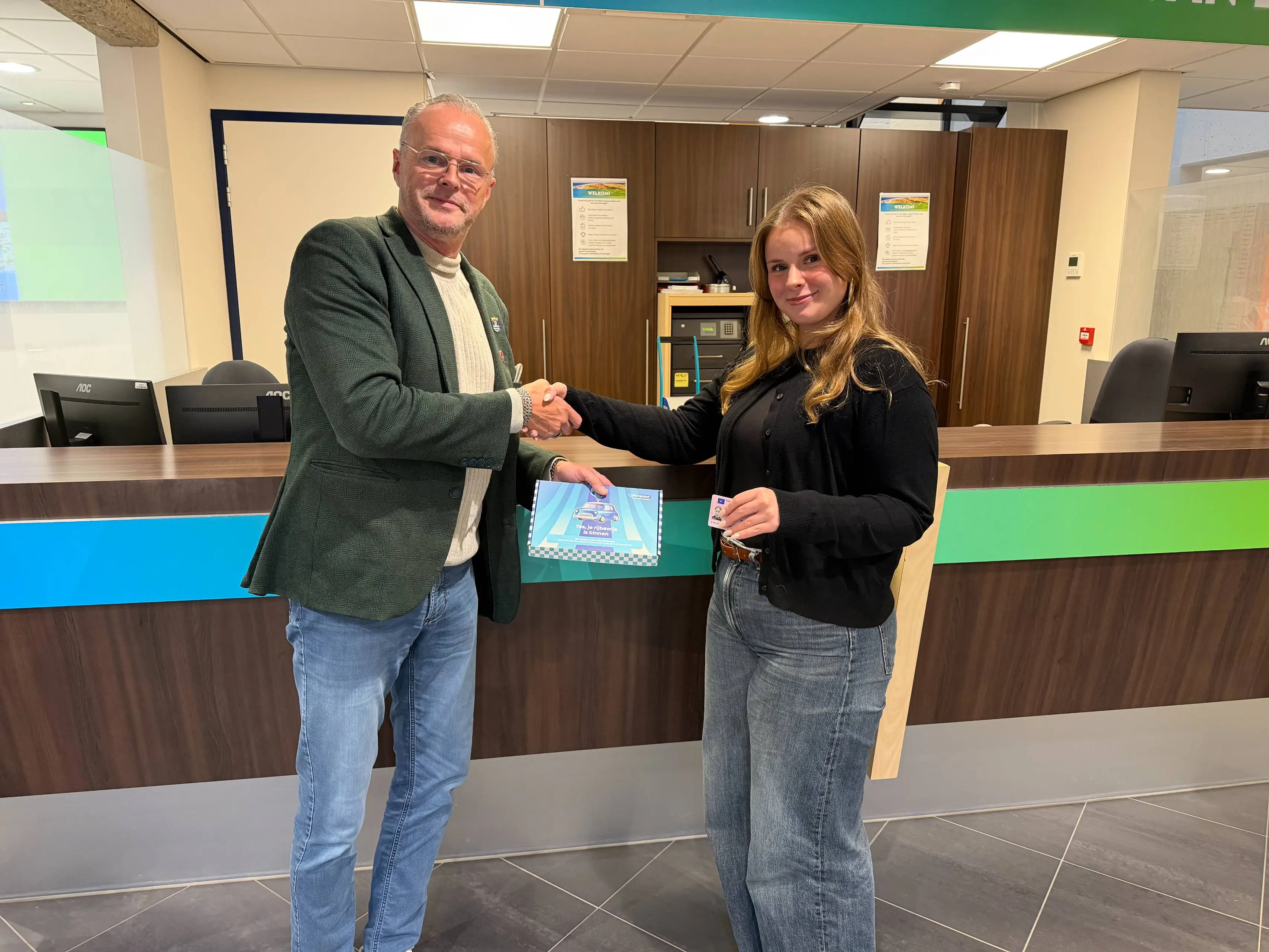 Wethouder Hans Veentjer reikt eerste rijbewijspakketje uit aan Sophie Nagtegaal