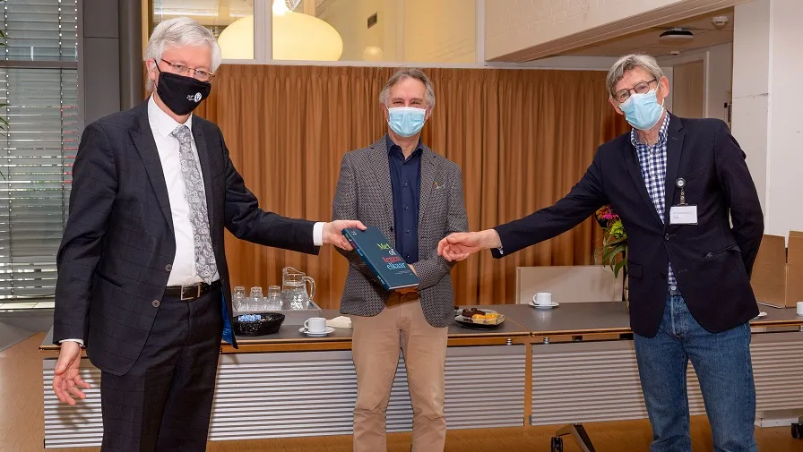 overhandiging boek met of tegen elkaar 1