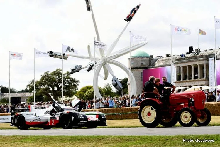 a tractor pulls a porsche 919 001