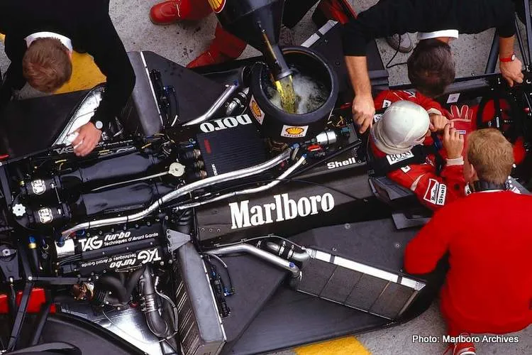 alain prost sits in his mclaren mp4 3 tag porsche while the mechanics get to work on the car and refuel