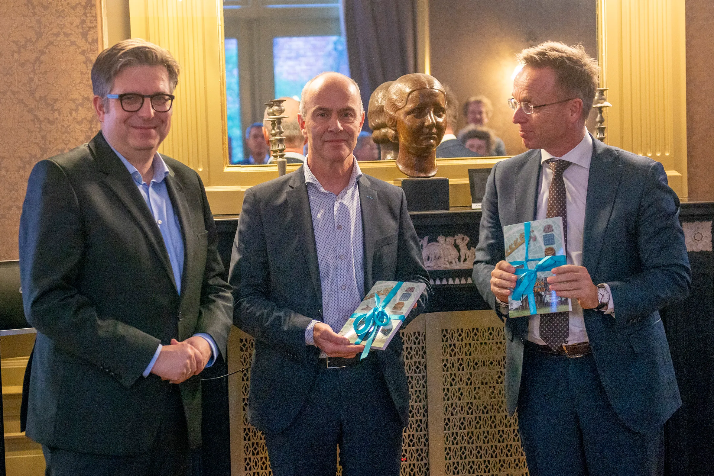 groningen boek overhandiging hervonden stad door wethouder van der schaaf 01 1 op de foto staan vlnr wethouder roeland van der schaaf hans biemans lid college van bestuur rug cdk ren paas