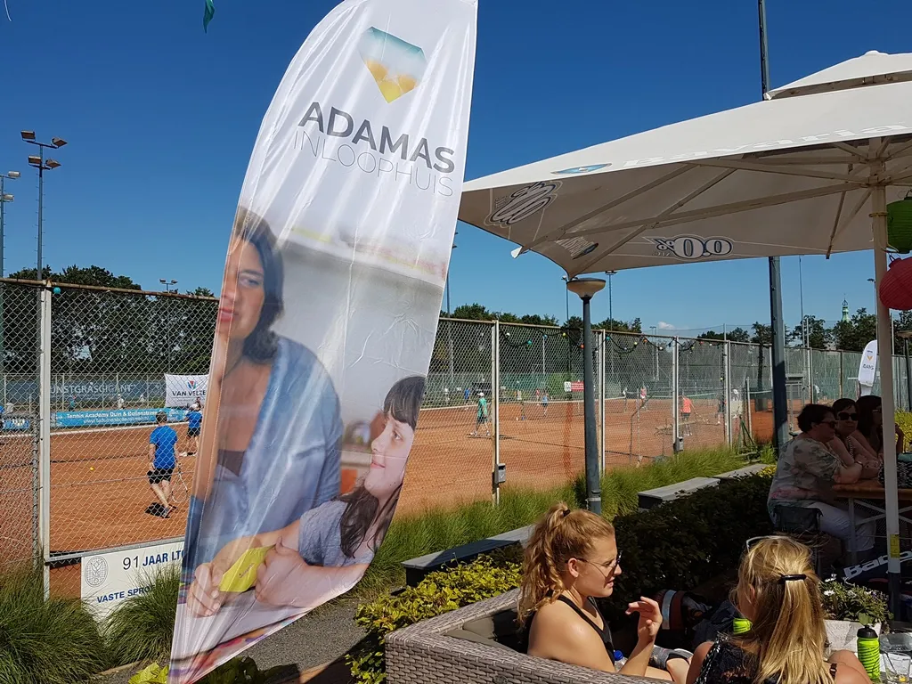tennistoernooi met beachflag aangepast adamas inloophuis