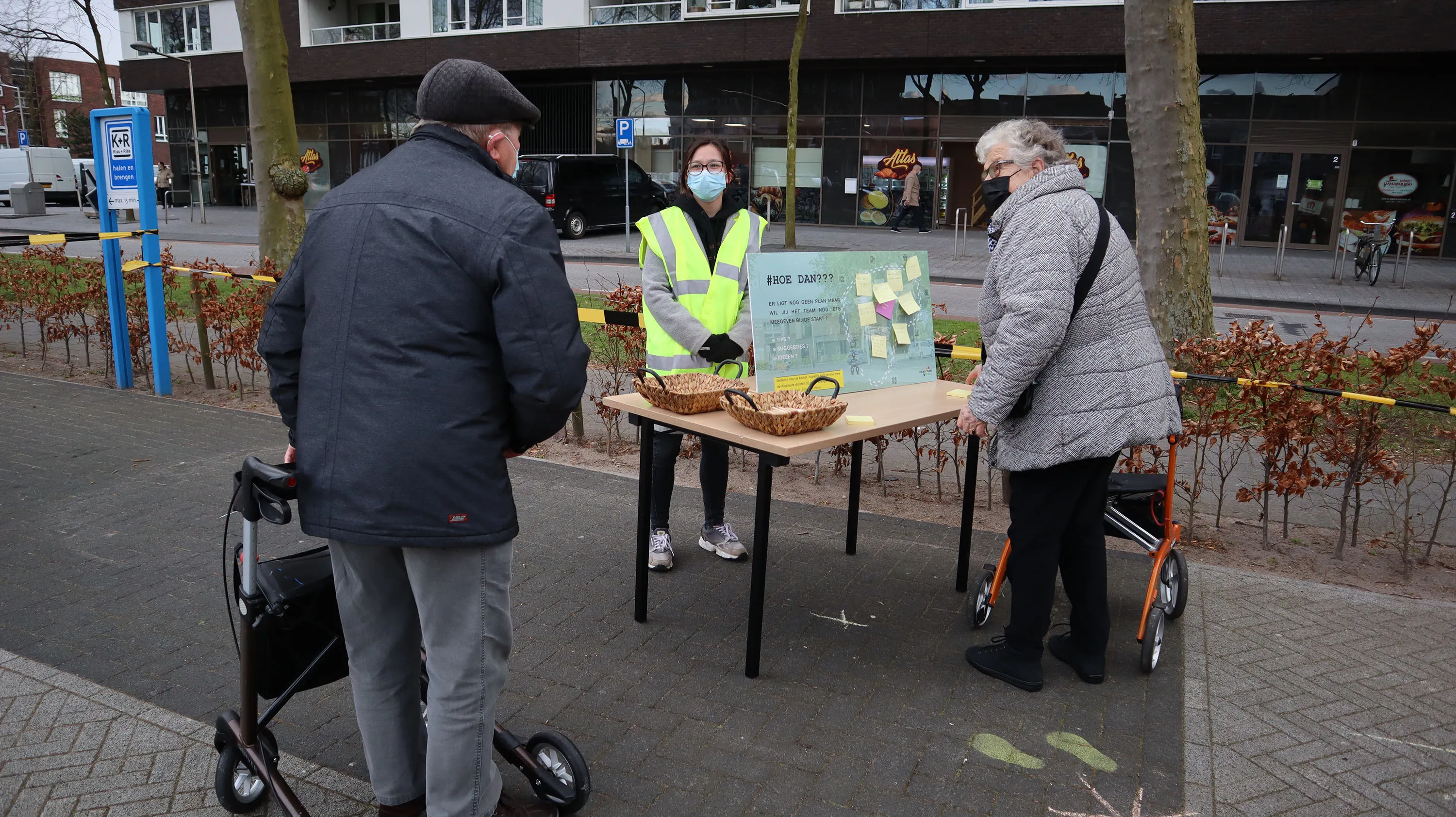 inwoners van stadsdennen bekijken een informatiebord tijdens het ommetje kiekmure