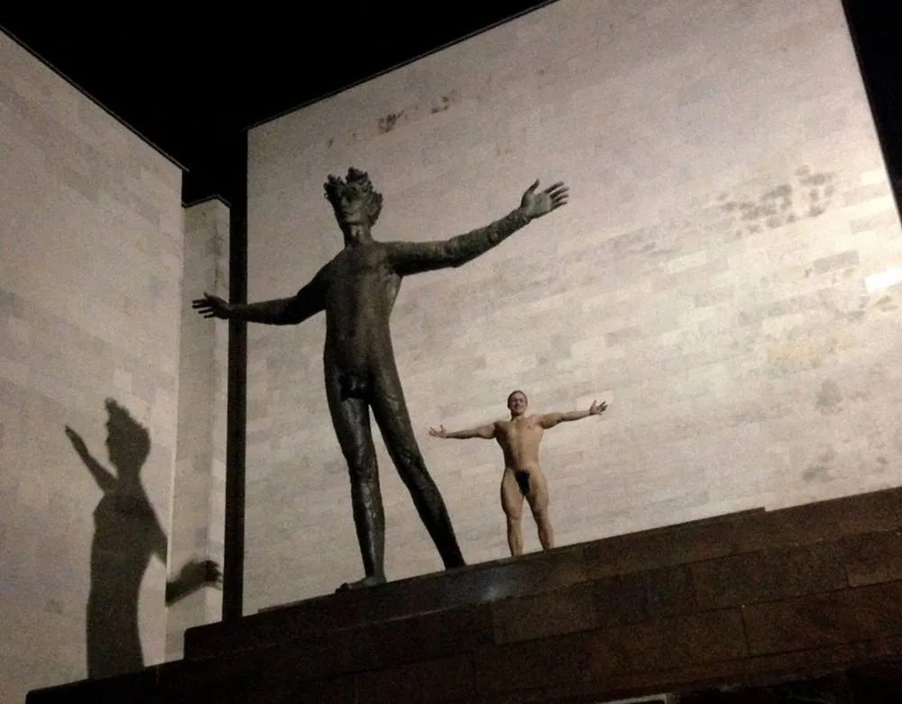 Kaunietis pozuoja šalia "Žmogaus" skulptūros