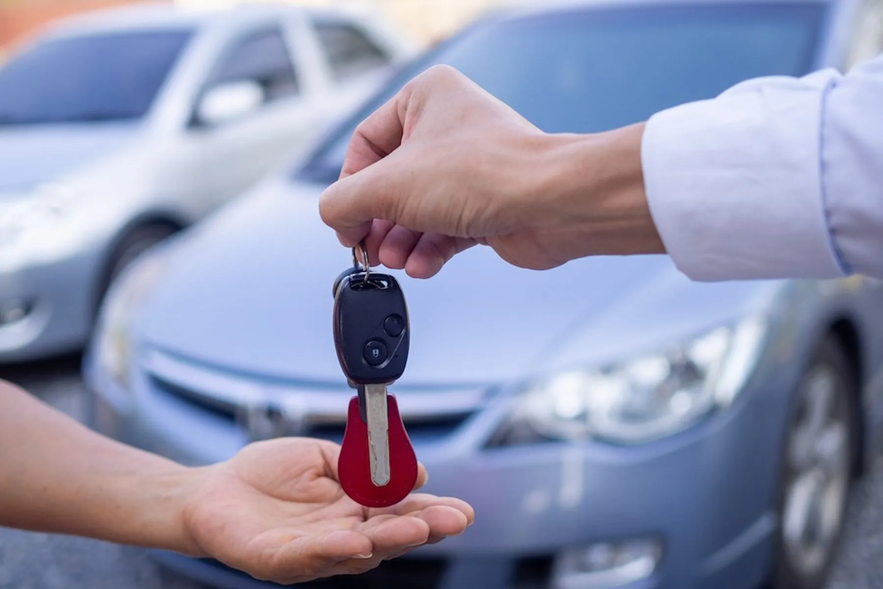 The car salesman and the key to the new owner.