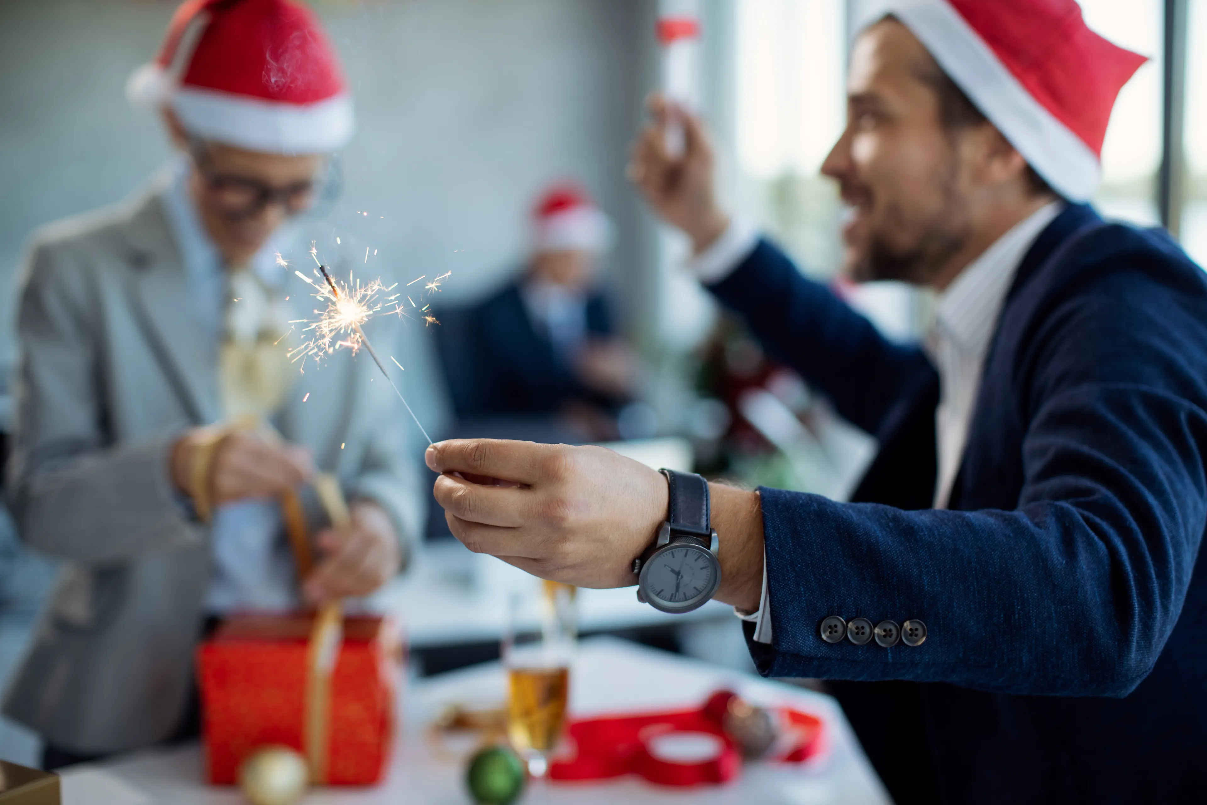 Close-up of businessman using sparkler on New Year's party in th