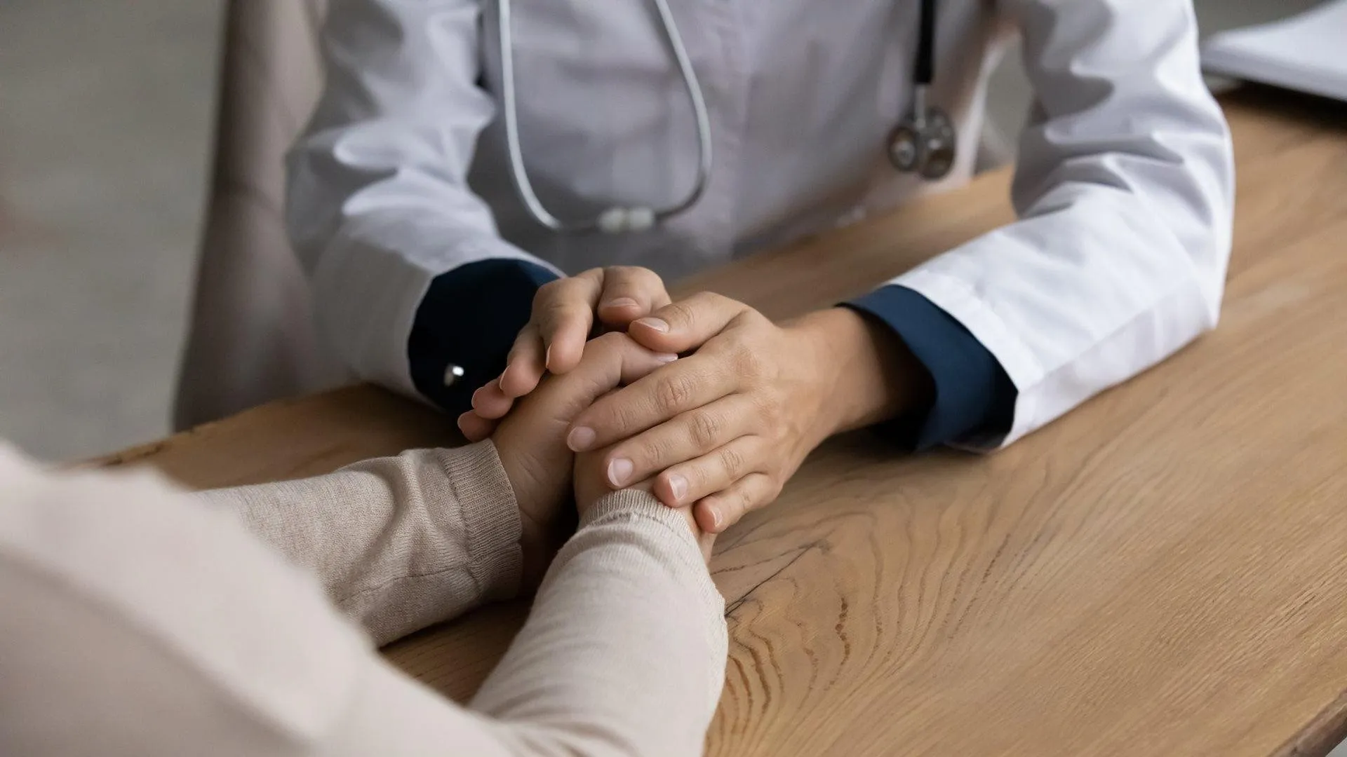 huisarts houdt hand van patient vast