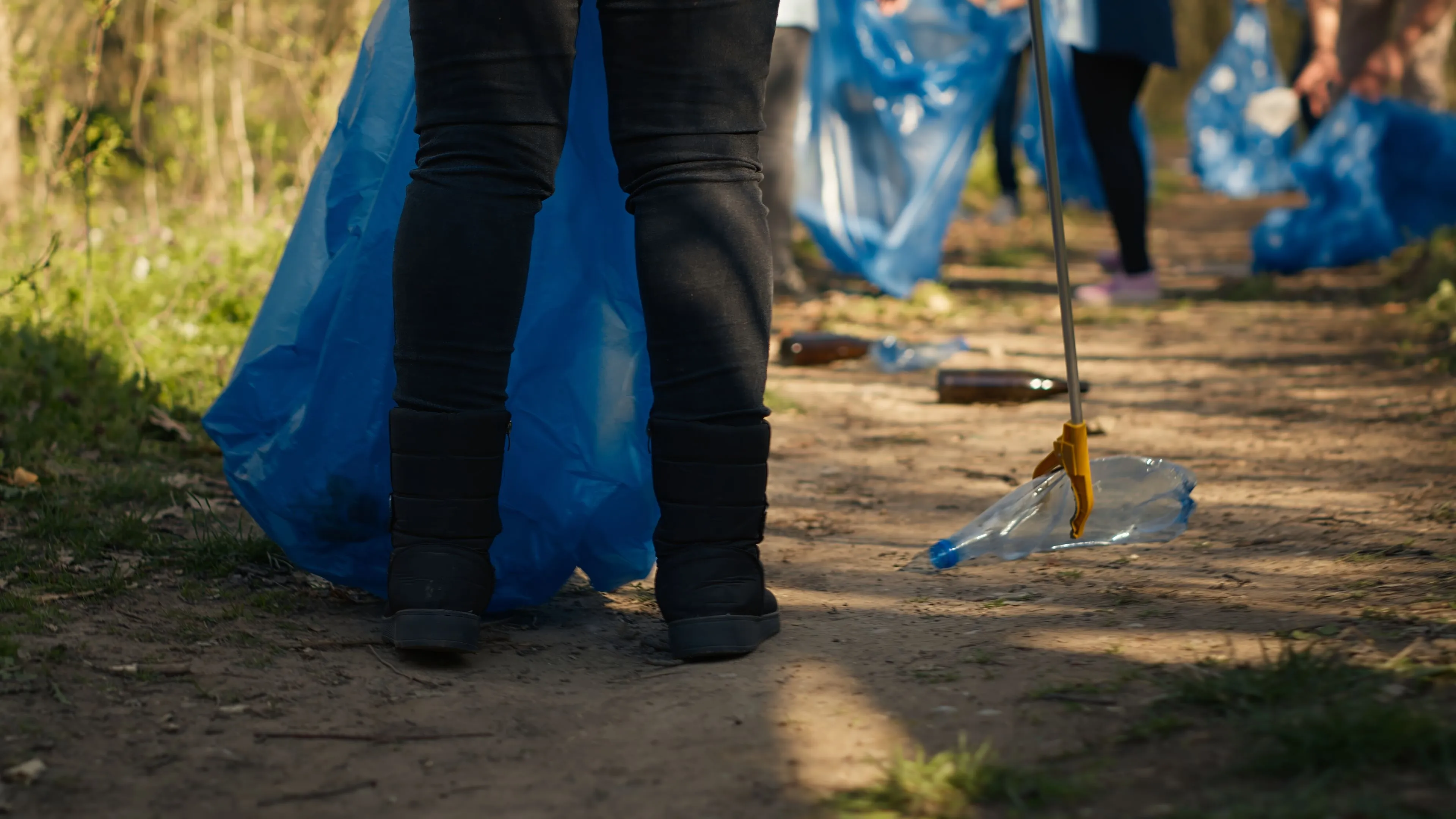 diverse activists group using claw tools grab trash plastic