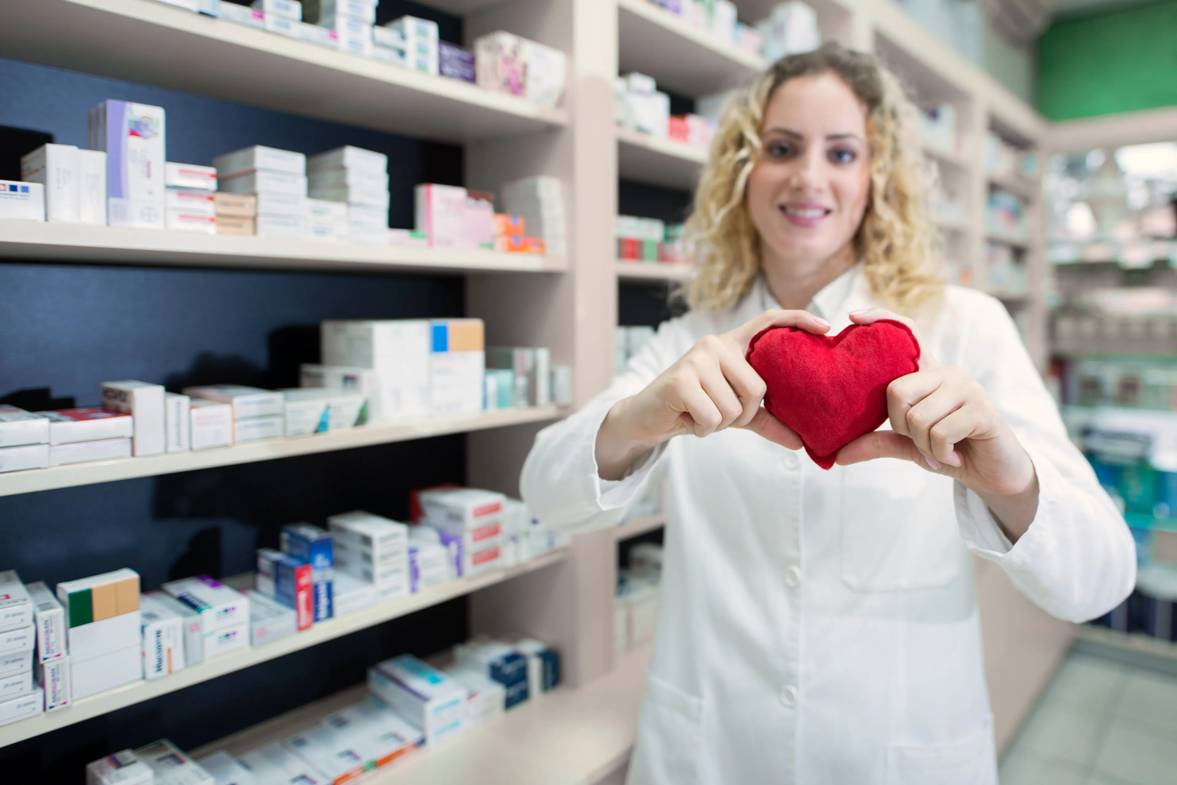female pharmacist holding heart promoting cardiovascular medications successful treatment