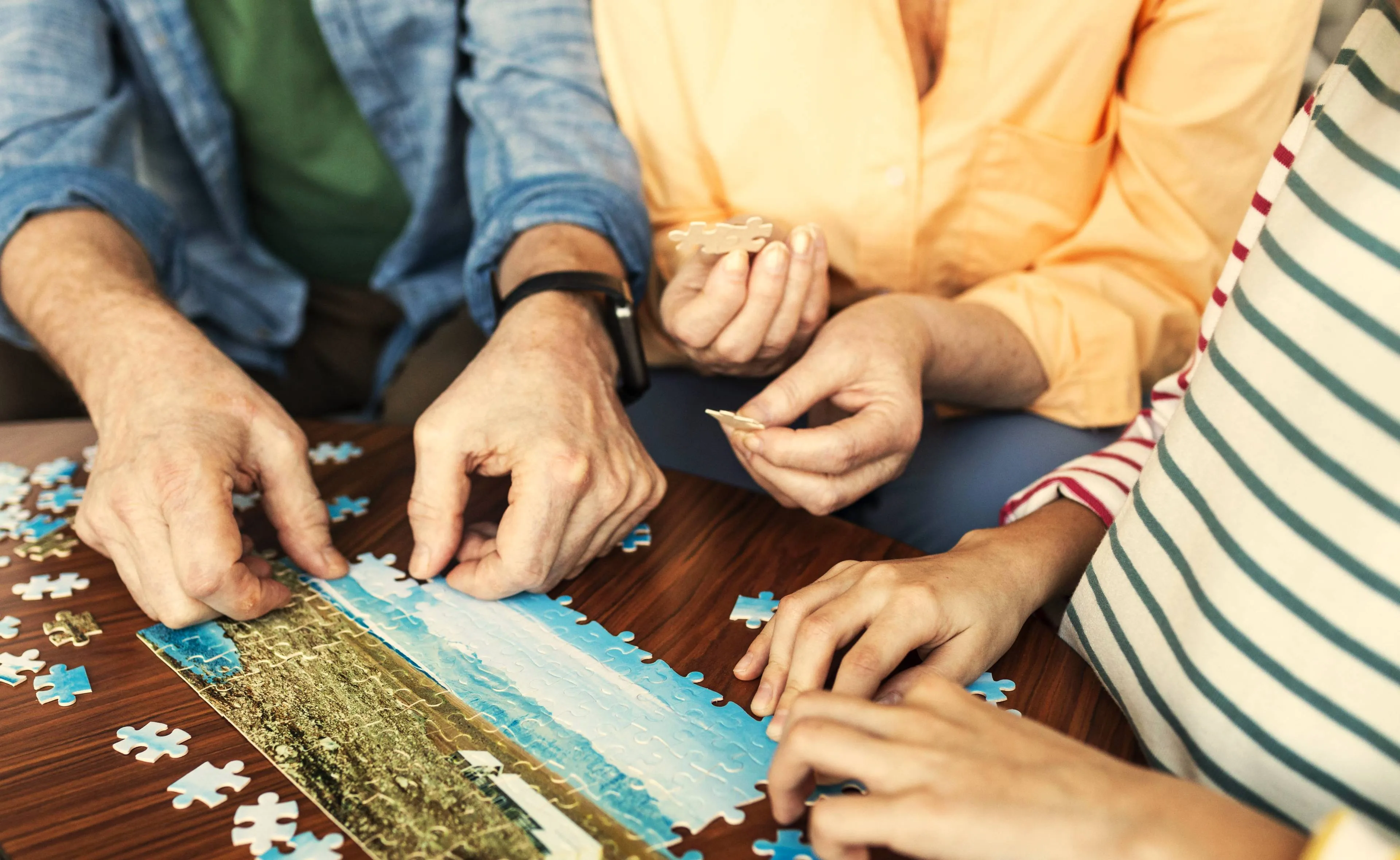 close-up-people-doing-puzzle-together