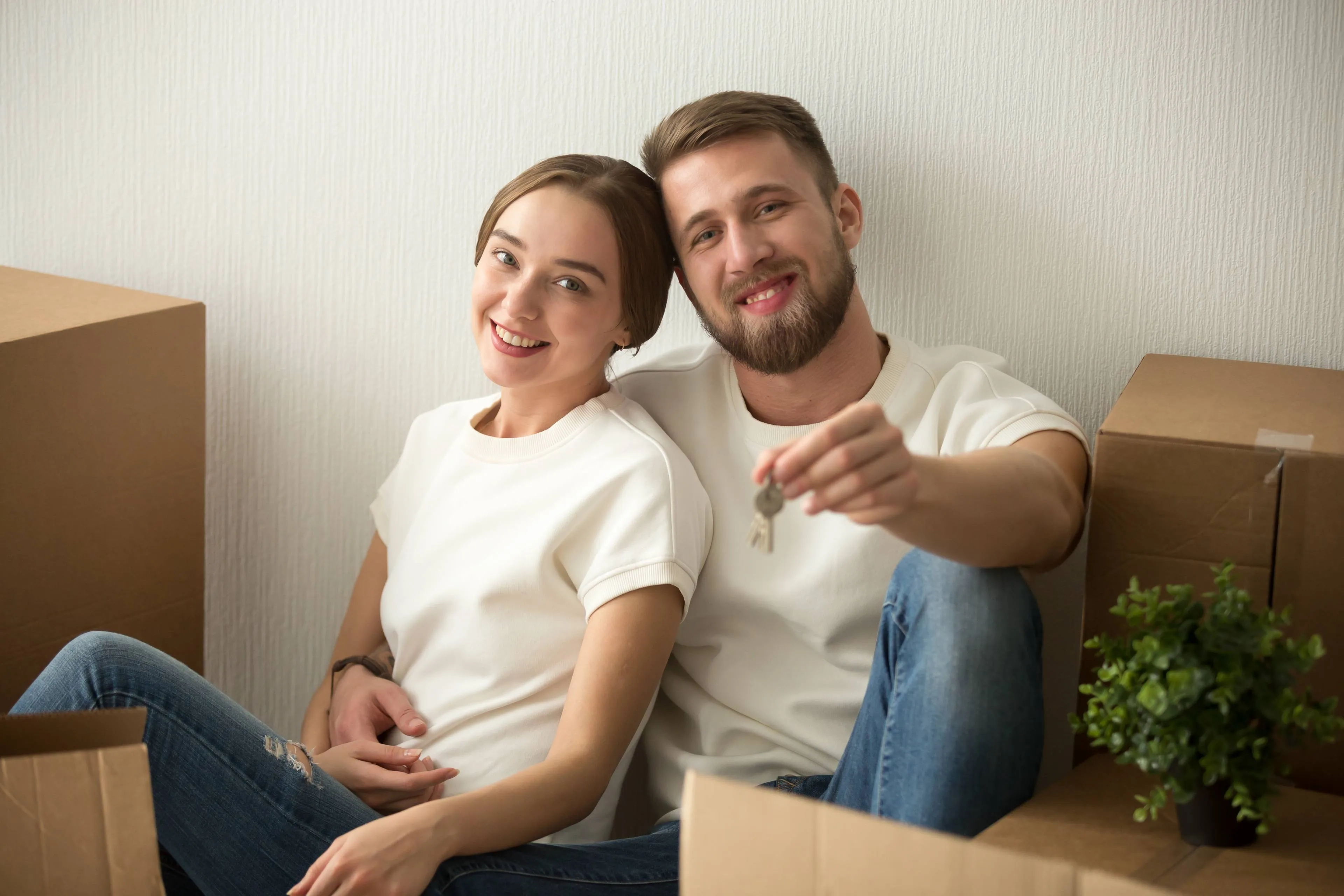 portrait-couple-holding-keys-excited-move-together