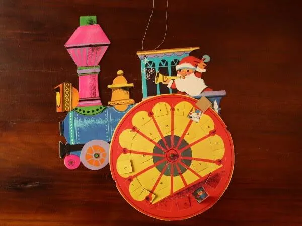 Adventskalender in de vorm van een trein met draaiend wiel, circa 1970-1973