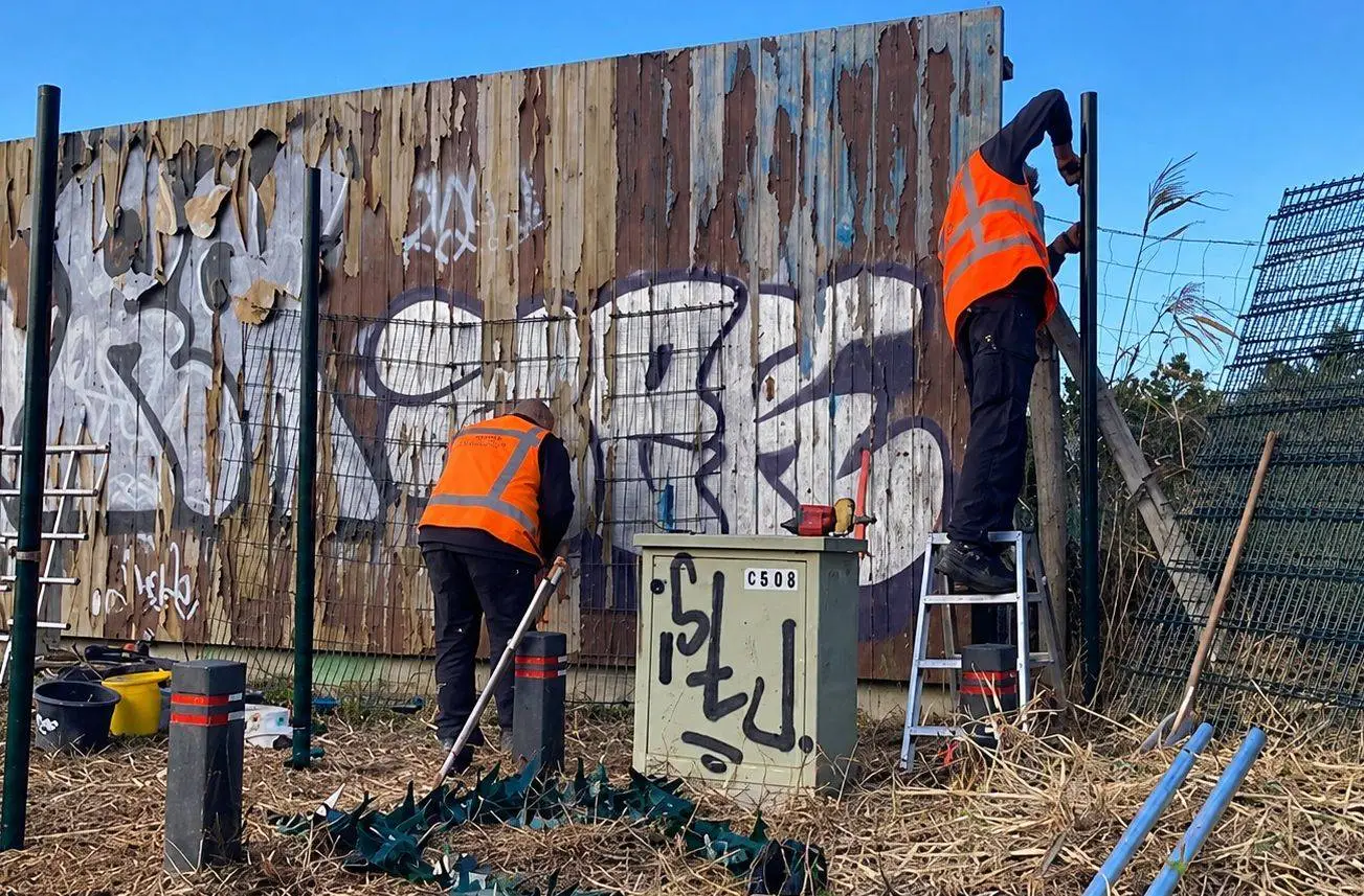 Werken aan een beschilderd hekwerk