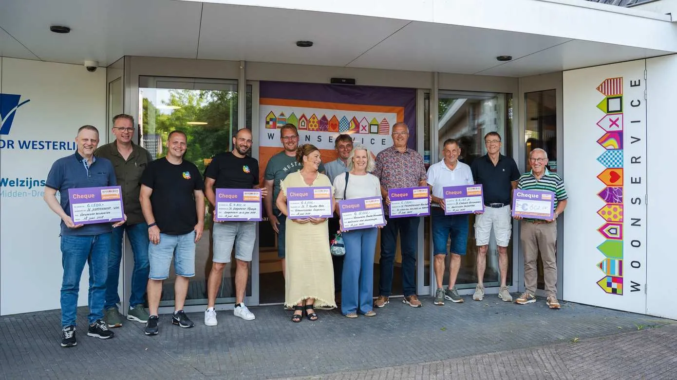 groepsfoto van de initiatiefnemers met woonservice buurtfonds cheque