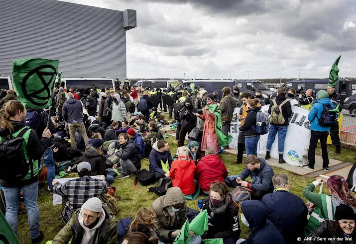 honderden klimaatactivisten met zang en vlag op eindhoven airport