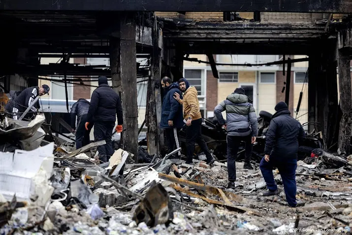 mannen klimmen over omheining op plaats explosie rotterdam
