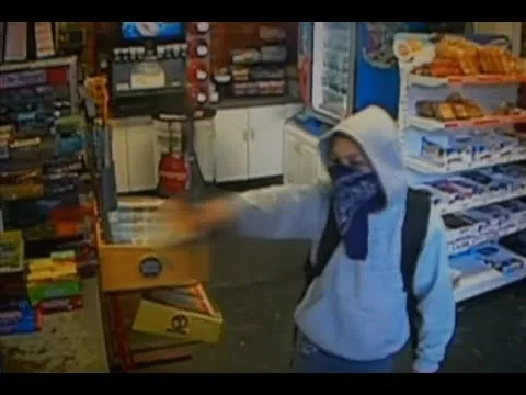 video 11 jarige jongen met een skateboard en een blauwe bandana berooft een winkel
